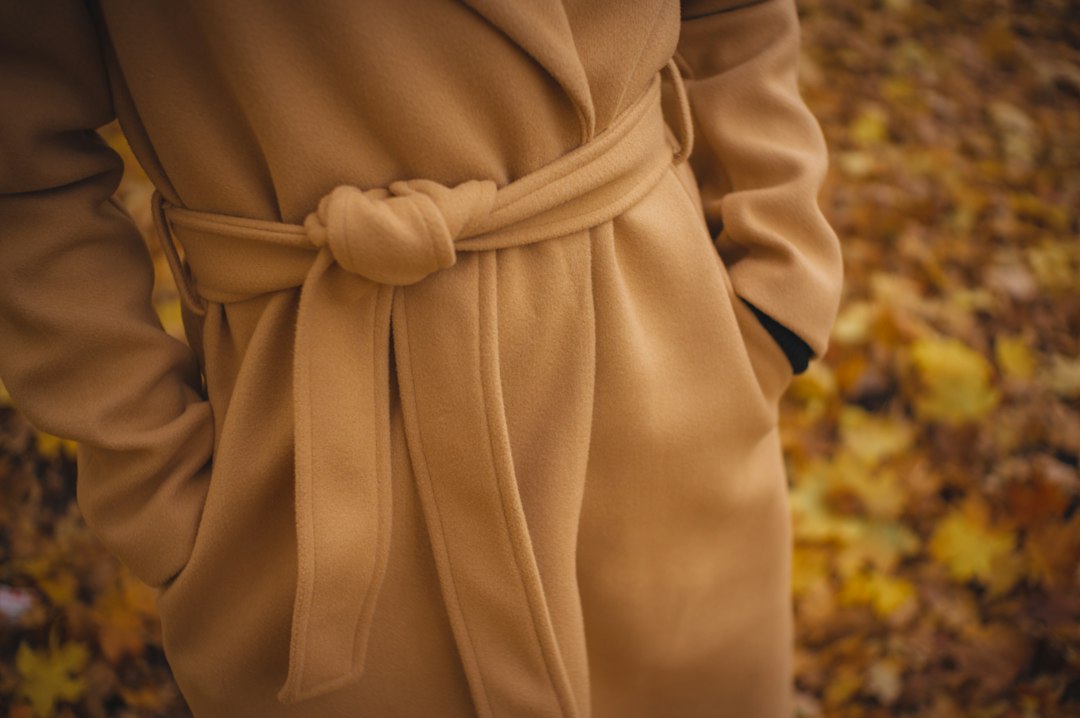 Detail hnědého kabátu s páskem