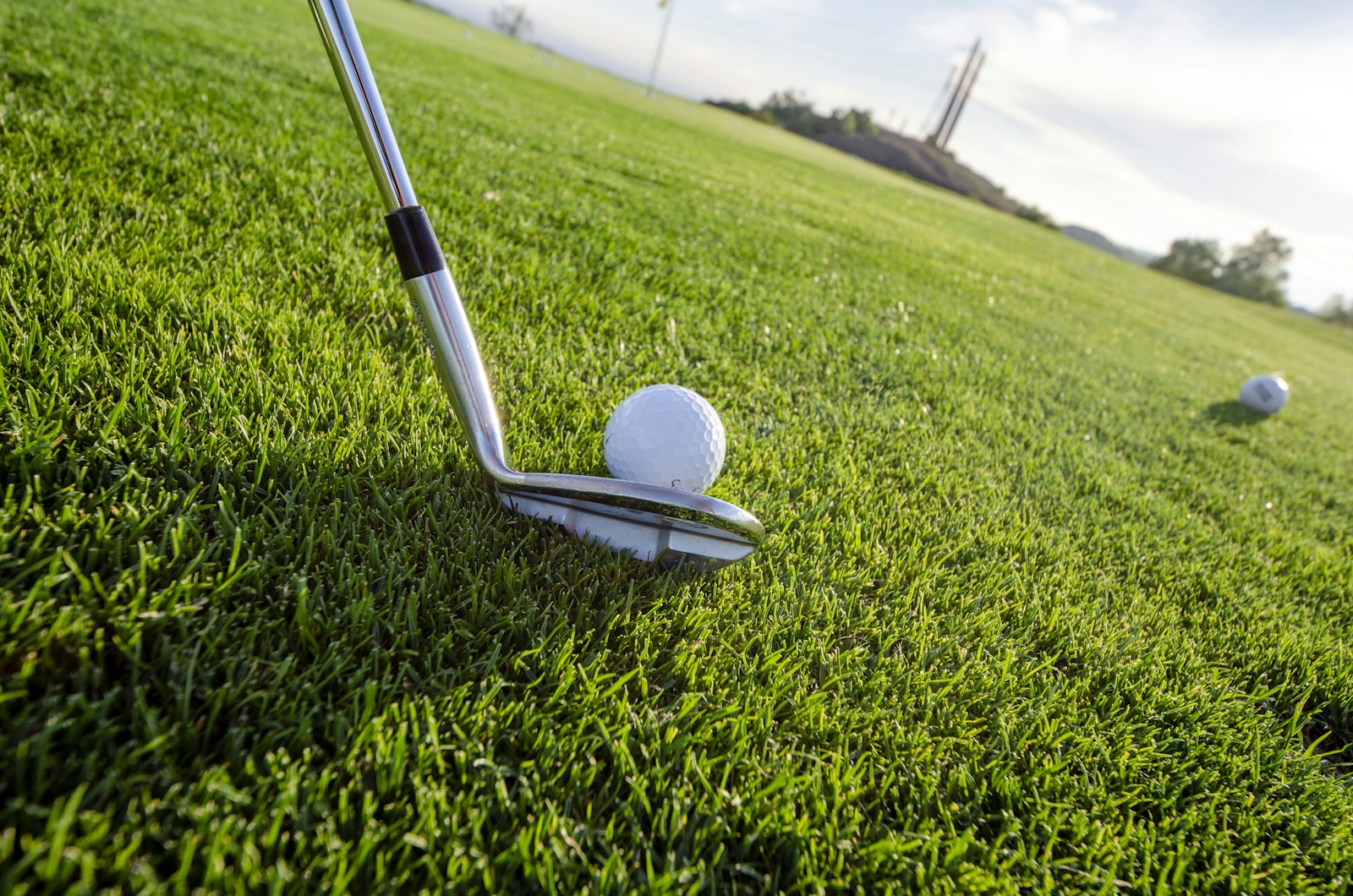 Putter u golfového míčku na greenu, ilustrační fotografie